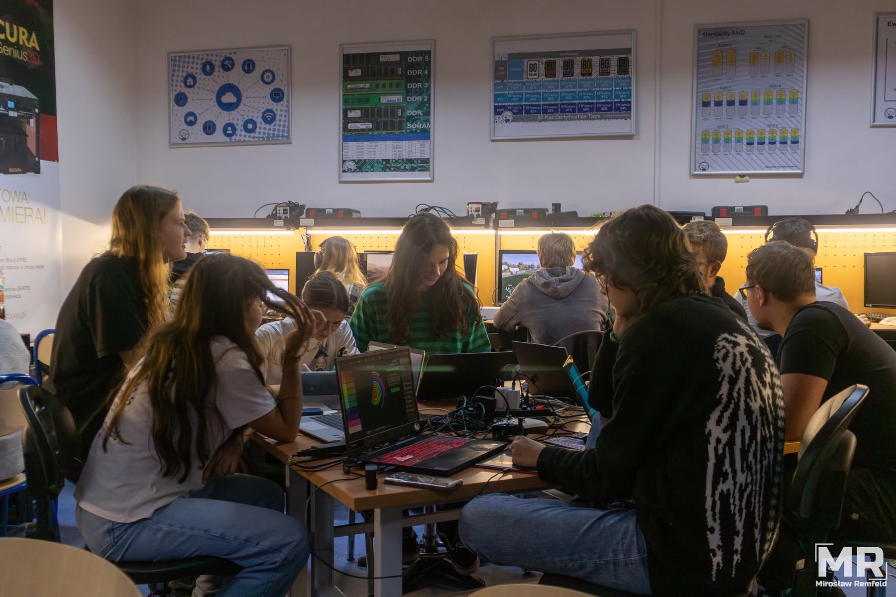 Kółko informatyczne "GITES" w ZSE nr 2 Na grafice znajduje się młodzież, siedzą w klasie szkolnej i pracują na sprzęcie komputerowym