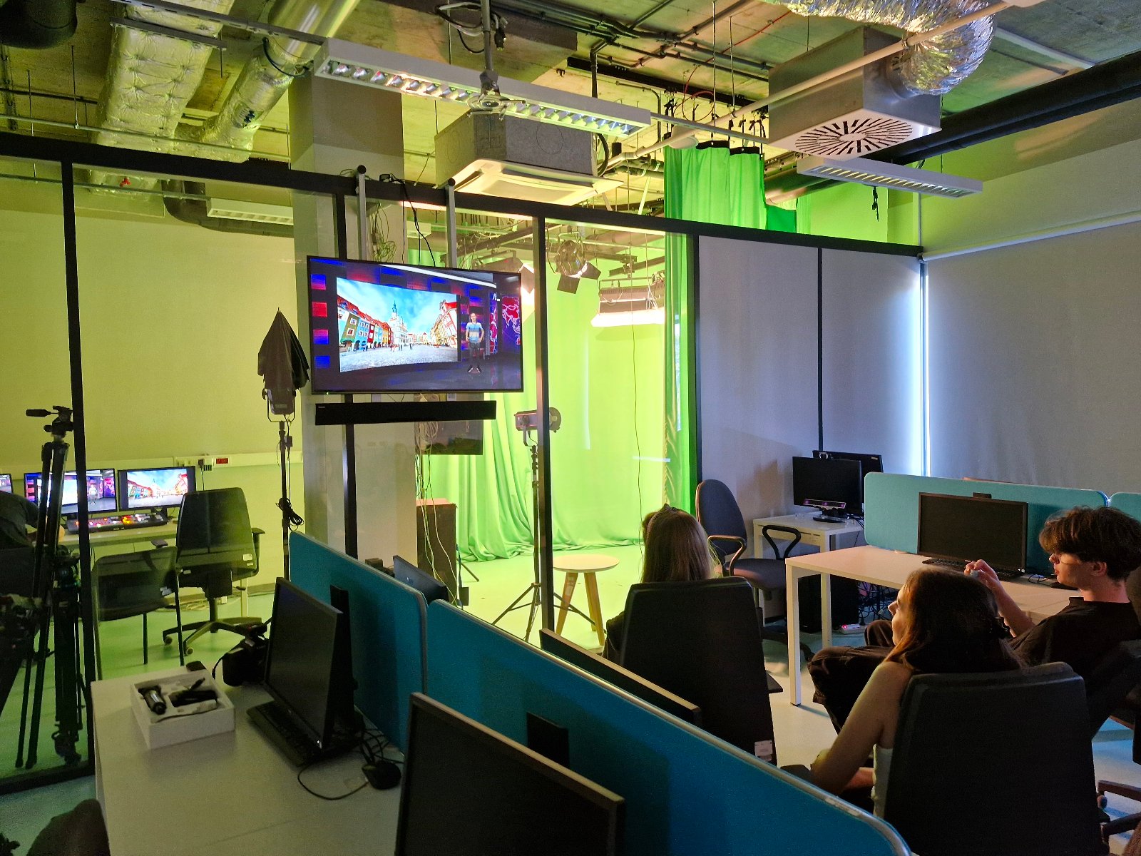 Na zdjęciu młodzi ludzie w laboratorium IT, uczą się z wykorzystaniem programu wyświetlanego na ekranie telewizora.