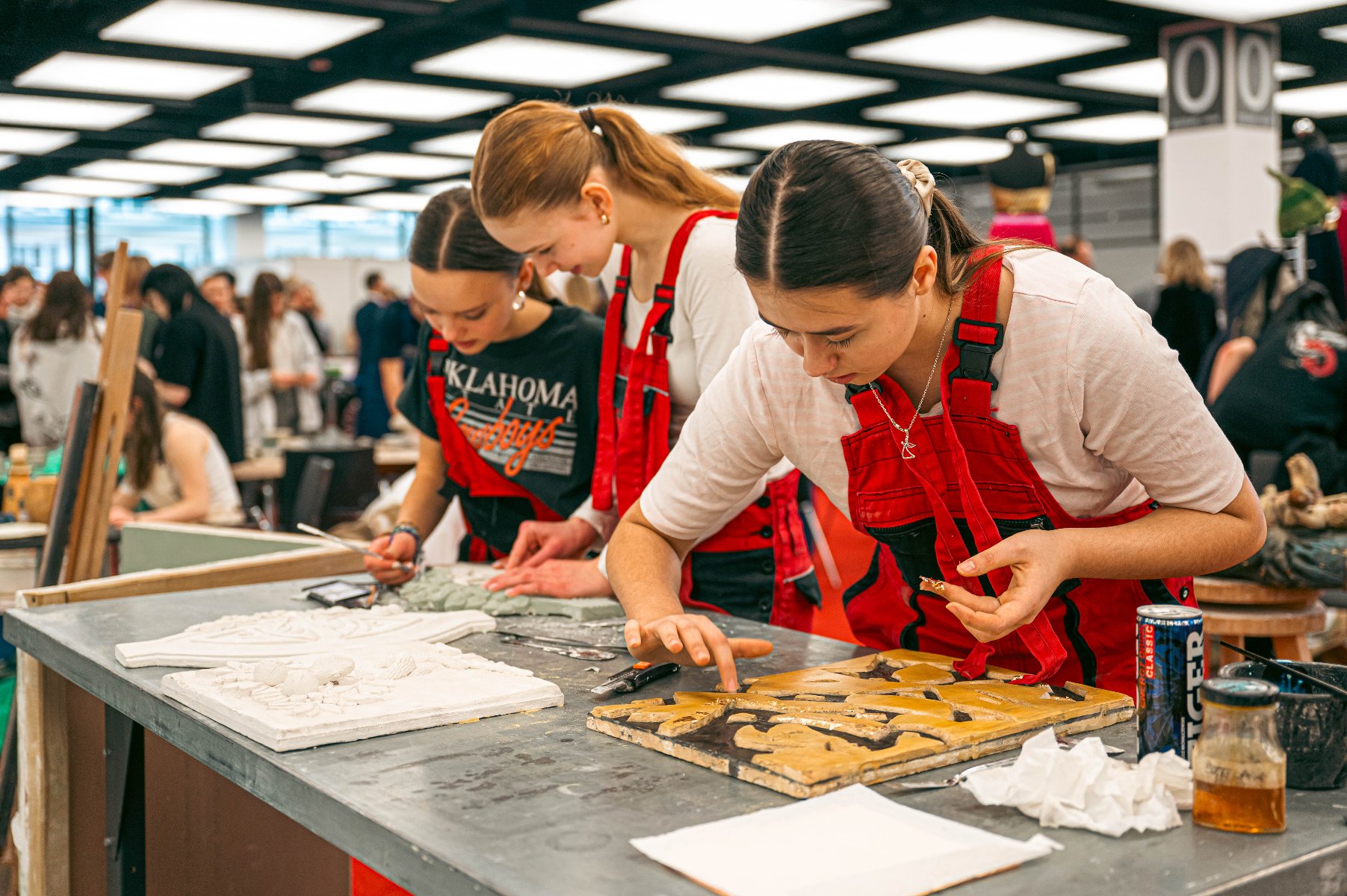 Zdjęcie przedstawia młodą dziewczynę czeszącą drugą dziewczynę.