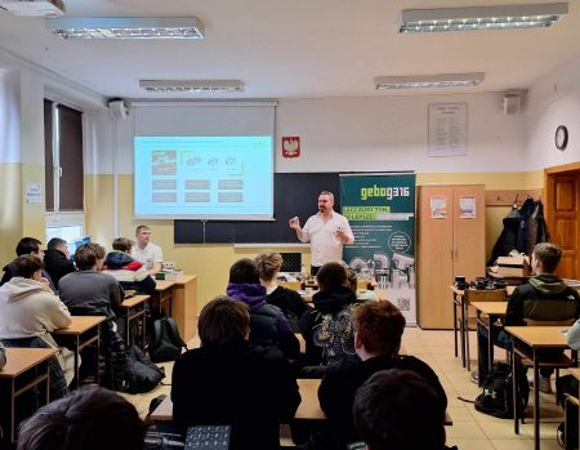 Zdjęcie przedstawia wykład z uczniami w sali lekcyjnej